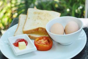 a plate with eggs and bread and a bowl of butter at Bokre Angkor Hostel in Siem Reap
