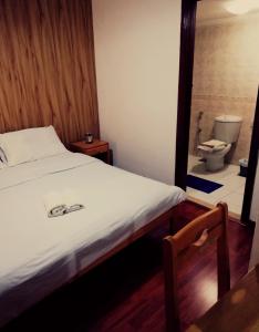 a bedroom with a bed and a bathroom with a toilet at Dynasty Suite in Aley