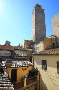 
a very tall building with a clock on it's side at Fabio Apartments San Gimignano in San Gimignano
