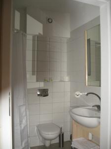 a white bathroom with a sink and a toilet at 5A Hotel Services in Koszalin