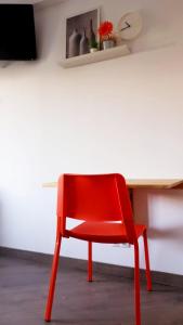 a red chair sitting in front of a desk at Pensión La Estrella in Zaragoza