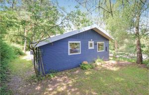a blue tiny house in the woods at 2 Bedroom Nice Home In Ebeltoft in Ebeltoft