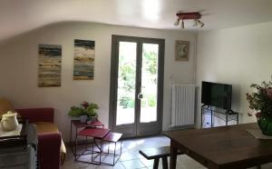 a living room with a table and a tv at Le Mesnil in Dancé