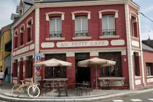 un bâtiment rouge avec des tables et des parasols dans une rue dans l'établissement Studio "Brume d'opale" au 2ème étage, à 200M de la plage, à Cayeux-sur-Mer 16 autres photos