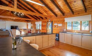 a large kitchen with wooden walls and wooden floors at 63 Milkwood in Knysna
