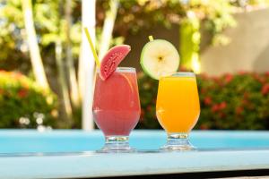 two cocktails sitting on a table with a drink at Pousada o Caribe de Maragogi in Maragogi