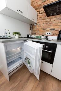 cocina blanca con nevera abierta en Loft Paprotka Premium Apartment, close to MTP Expo, F.VAT, en Poznan