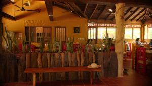 a wooden bench in a restaurant with a hat on it at Samadhi Ecohotel by Rotamundos in Puerto Escondido