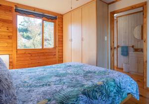 a bedroom with a bed with a blue blanket at 63 Milkwood in Knysna