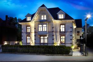 uma grande casa branca com as luzes acesas em Hotel Villa8 em Villingen-Schwenningen