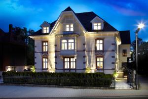 a large white house with its lights on at Hotel Villa8 in Villingen-Schwenningen