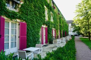 a row of pink doors and tables on a building at Le Manoir de Gressy in Gressy