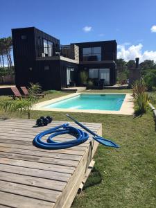 a pool with a blue hose next to a house at Pretas in Punta Del Diablo