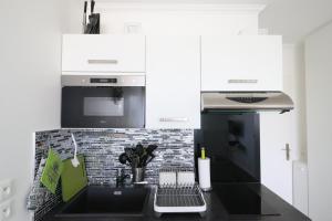 cocina con encimera negra y fogones en Studio scandinaves - Disneyland Paris en Serris