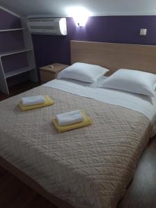 Apartments Mirjana في راب: غرفة نوم بسرير كبير عليها منشفتين