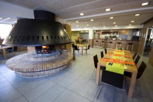 a restaurant with a fireplace in the middle of a room at Hotel y Apartamentos SNÖ Isaba in Isaba