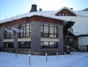 um grande edifício com neve no chão em Hotel y Apartamentos SNÖ Isaba em Isaba