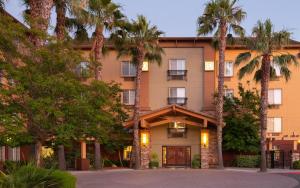 米爾皮塔斯的住宿－拉克斯普蘭廷貝勒維全套房酒店，前面有棕榈树的酒店