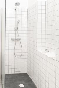 a bathroom with a shower with white tile walls at Design Loft Hohe Warte in Vienna