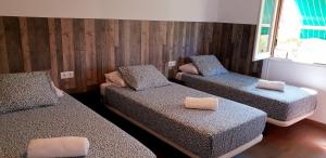 Habitación con 3 camas y almohadas. en Pensión La Estrella, en Zaragoza