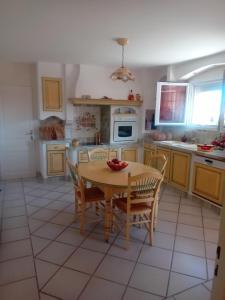 una cucina con tavolo e sedie in legno e una cucina con piano cottura di la maison du saunier a Salin-de-Giraud