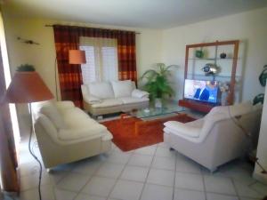 un soggiorno con 2 sedie bianche e un tavolo di la maison du saunier a Salin-de-Giraud