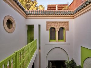 une maison avec un escalier et une rampe verte dans l'établissement Riad Volubilis, à Marrakech