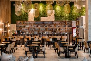 Tirat KarmelKedem Hotel - Adults Only的有桌椅和酒吧的餐厅