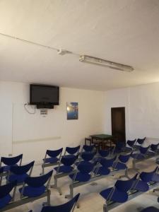 ポルト・チェルボにあるResidenza Chrysalis Bayの青い椅子と薄型テレビが備わる客室です。