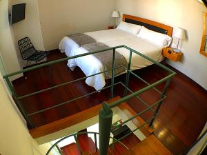 a small bedroom with a bed and a staircase at Hotel Rural Triana in Vallehermoso