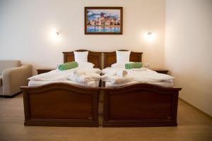 two twin beds in a room with at Luxury Hotel Siófok in Siófok