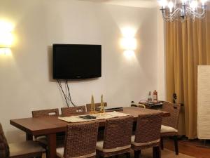 a dining room with a table and a television on the wall at Ski Terrace Heaven Partia Clabucet in Predeal