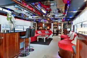 a living room with red couches and a bar at Absolute Pleasure Yacht in London