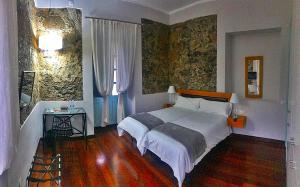 a bedroom with a large white bed and a table at Hotel Rural Triana in Vallehermoso