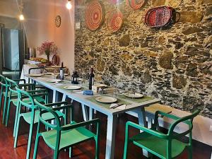 a table with green chairs and a stone wall at Hotel Rural Triana in Vallehermoso