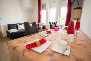 uma mesa de jantar com pratos vermelhos e brancos em Ferienwohnung Harztraum em Bad Sachsa