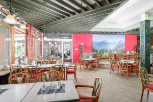 a restaurant with tables and chairs and a mural at Ferienclub Maierhöfen in Maierhöfen