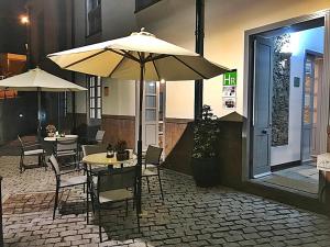 a patio with tables and chairs and an umbrella at Hotel Rural Triana in Vallehermoso