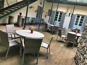an outdoor patio with tables and chairs and a building at Hotel Rural Triana in Vallehermoso