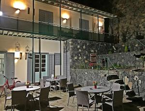 a restaurant with tables and chairs and a balcony at Hotel Rural Triana in Vallehermoso