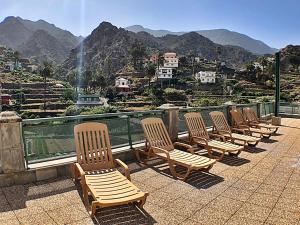 a row of chairs sitting on top of a balcony with mountains at Hotel Rural Triana in Vallehermoso