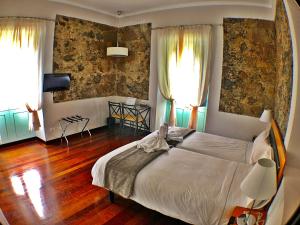 a bedroom with a large bed and two windows at Hotel Rural Triana in Vallehermoso