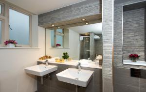 a bathroom with two sinks and a mirror at The Park City Grand Plaza Kensington Hotel in London +91 photos