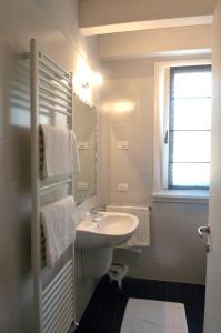 a white bathroom with a sink and a mirror at Affittacamere Sale e Pepe in Cavaion Veronese +16 photos