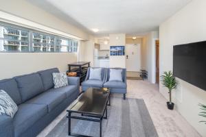 a living room with a couch and a tv at Ocean View from Lanais-2 Blocks to Waikiki Beach in Honolulu