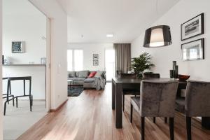 comedor y sala de estar con mesa y sillas en Lunas Appartements Essen, en Essen