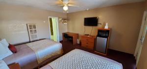 una camera d'albergo con due letti e una televisione di The L Motel Downtown/NAU Conference Center a Flagstaff