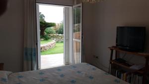 a bedroom with a bed and a sliding glass door at villa PICOZZI cannigione in Cannigione