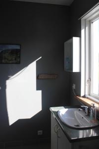 a bathroom with a sink and a window at Icelandhorsetours - Helluland in Sauðárkrókur +25 photos