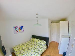 Dormitorio pequeño con cama con manta amarilla en The Mountain View Innsbruck, en Innsbruck